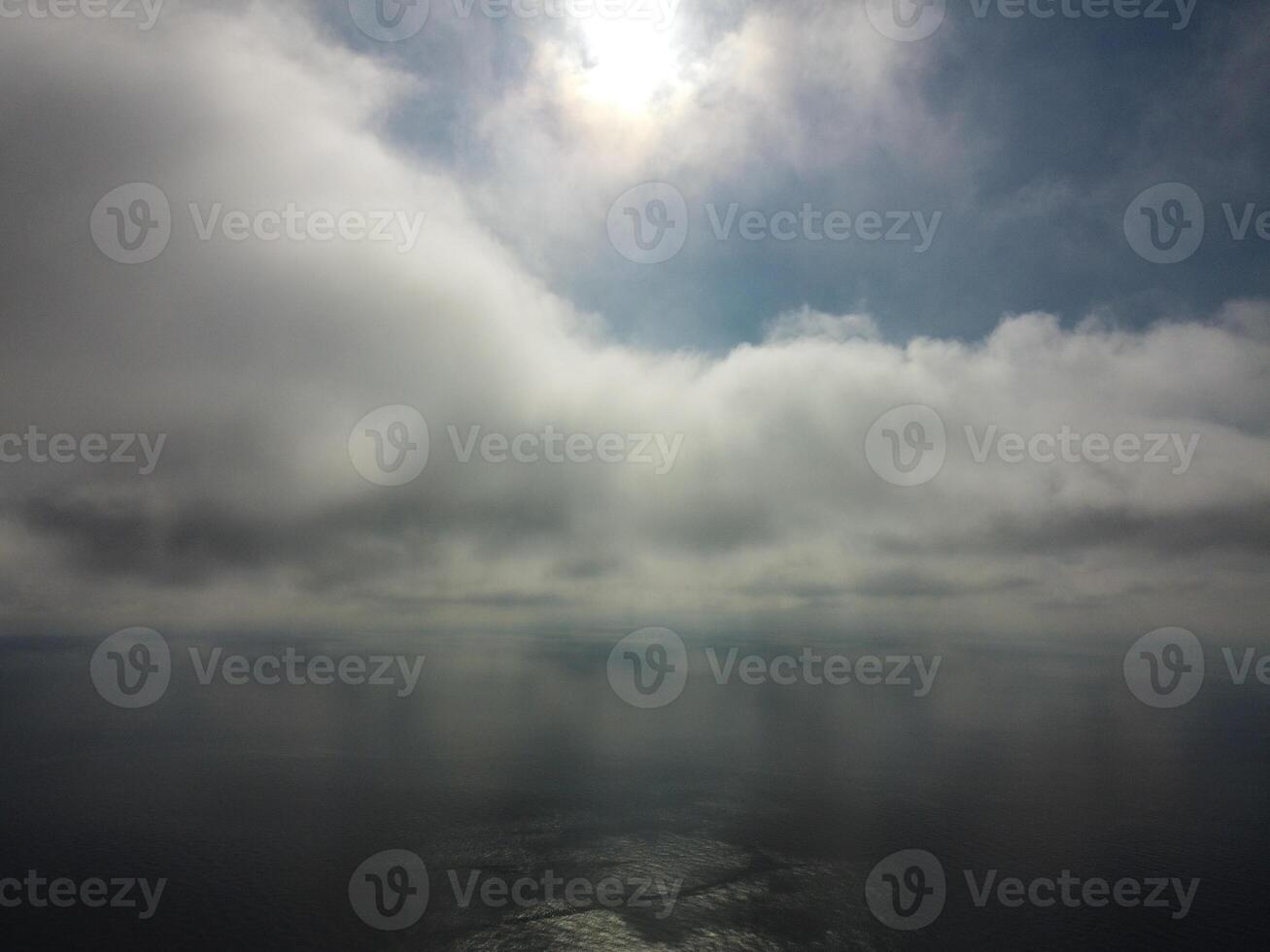 Aerial view. The drone flies over foggy and fluffy clouds. Blue sky sun and sea fog. Abstract aerial nature summer ocean sunset sea and sky background. Vacation, travel and holiday concept photo