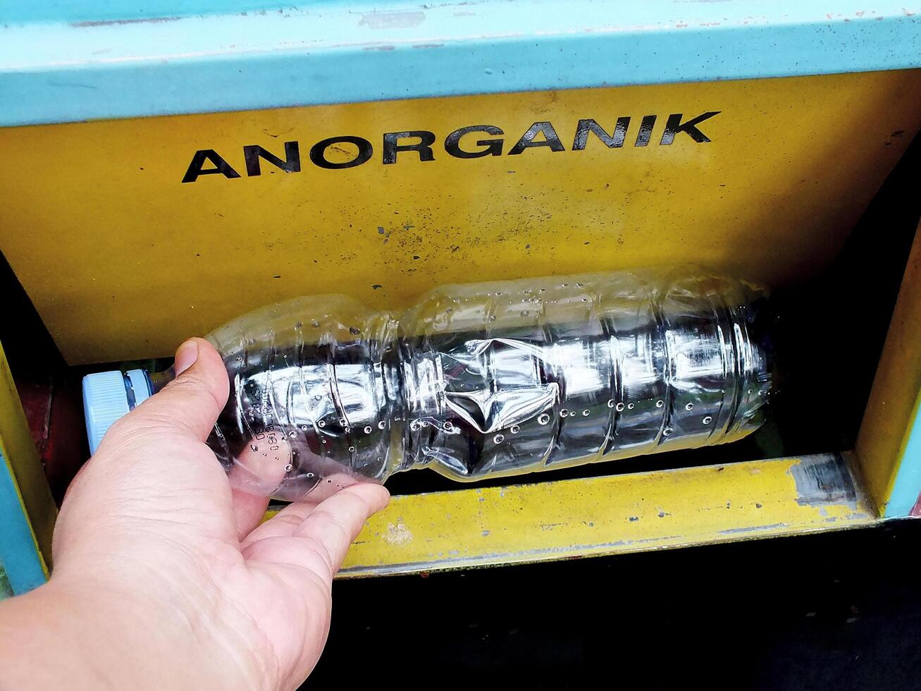 hand holding a plastic bottle thrown into the trash. environmental issue. earth day concept, sustainability. photo
