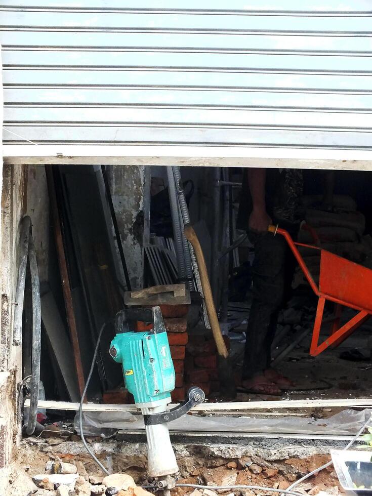 construction workers work to repair a shop. The shop door was half closed, only showing the worker's feet. The door perform a copy space for text ads photo