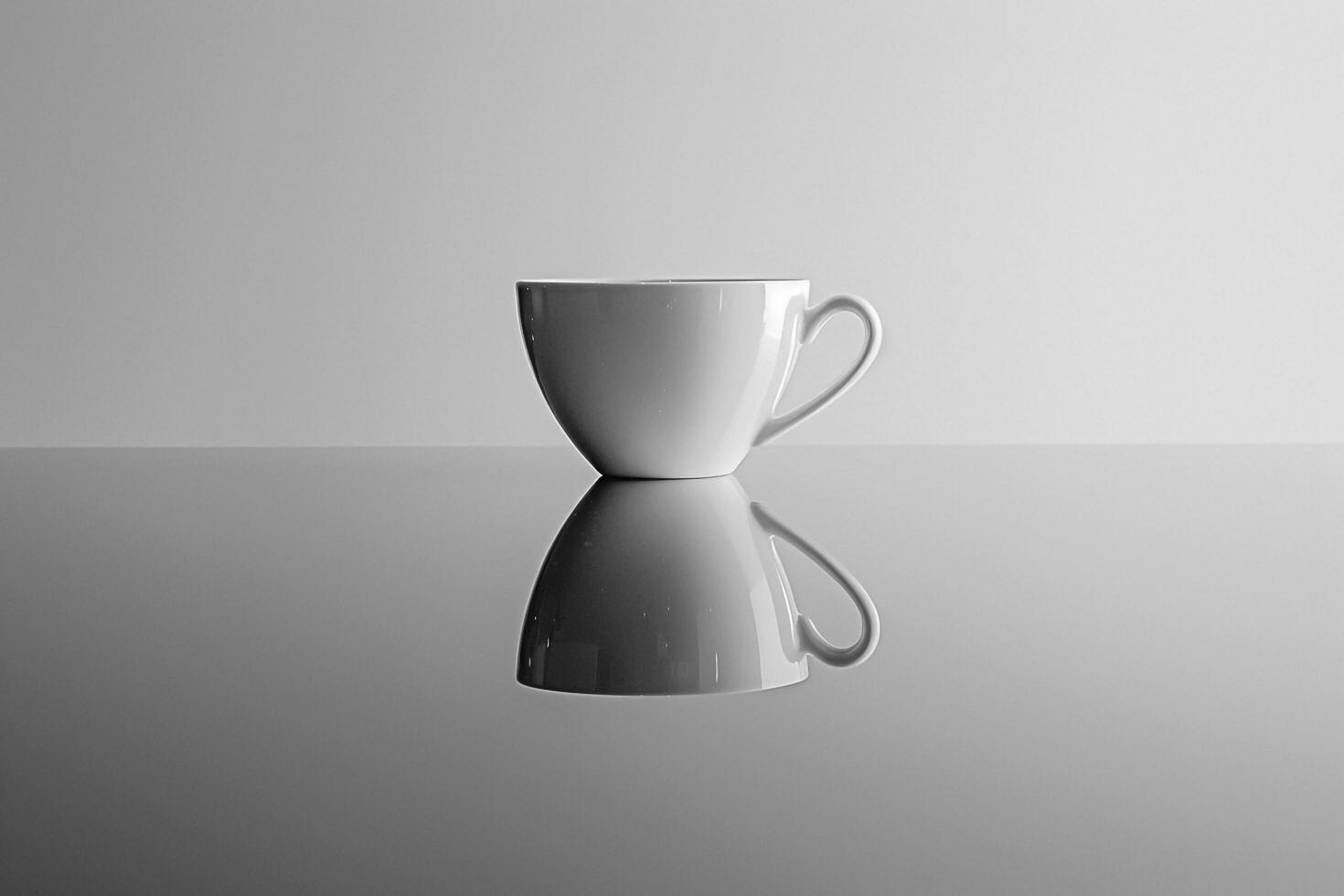 A coffee cup is reflected in a mirror photo