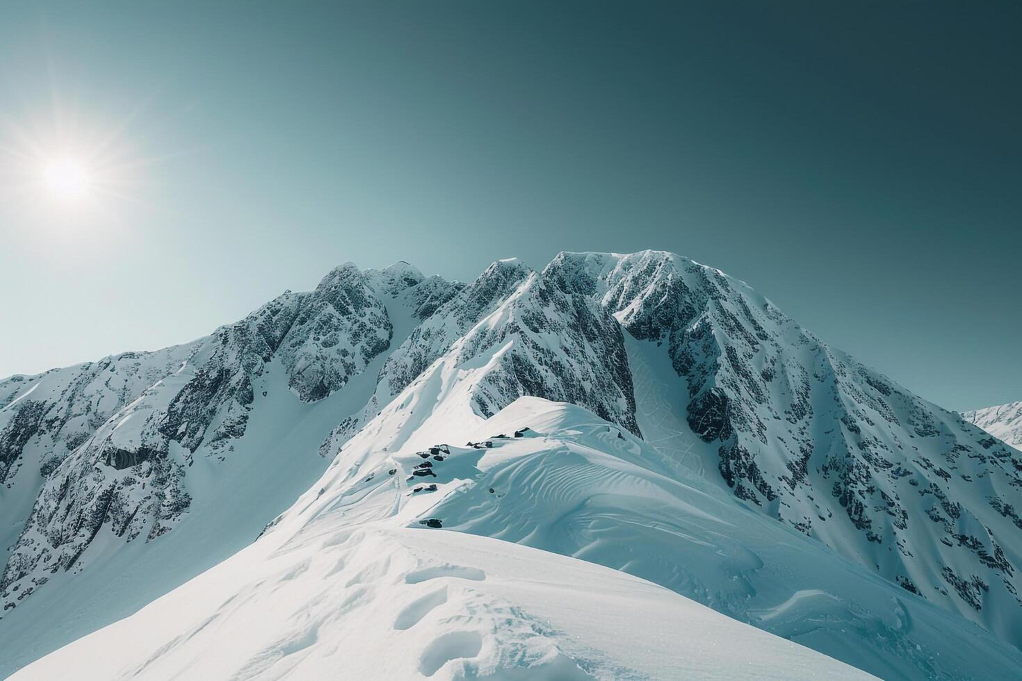 a mountain range with snowcovered mountains and a sun with a nature background photo