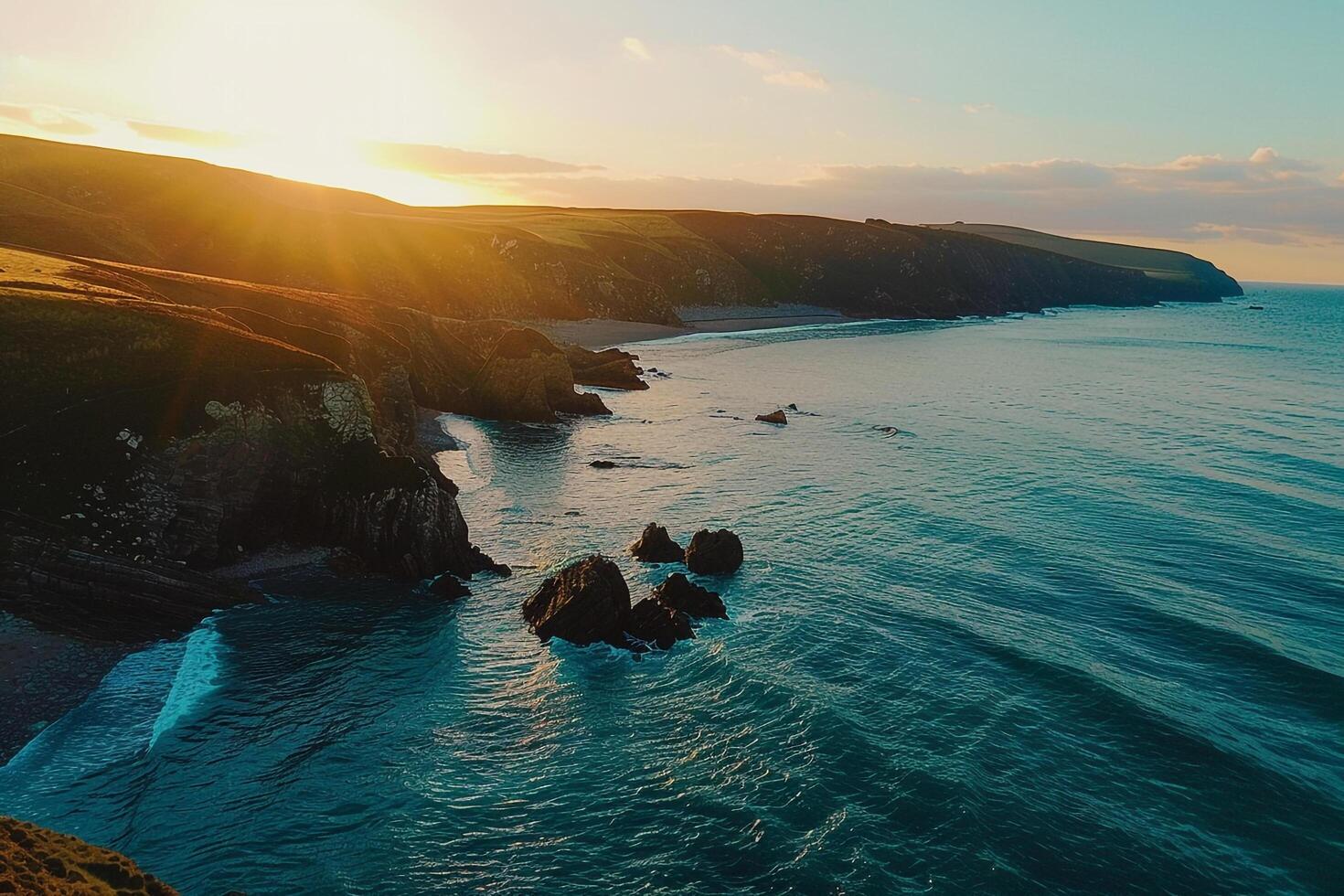 the sun is setting over the ocean and cliffs background photo