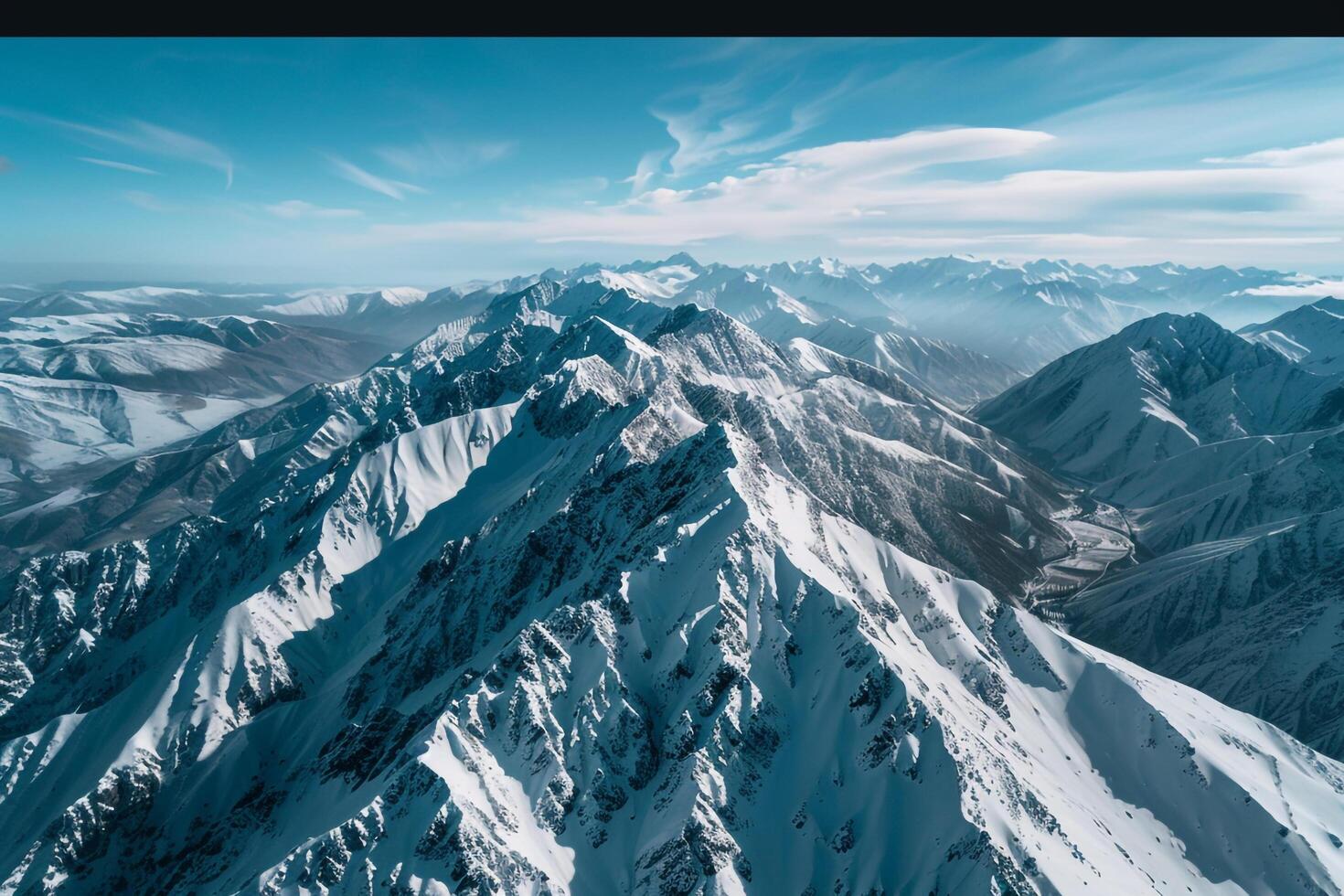 a mountain range with snow on top and blue sky background photo