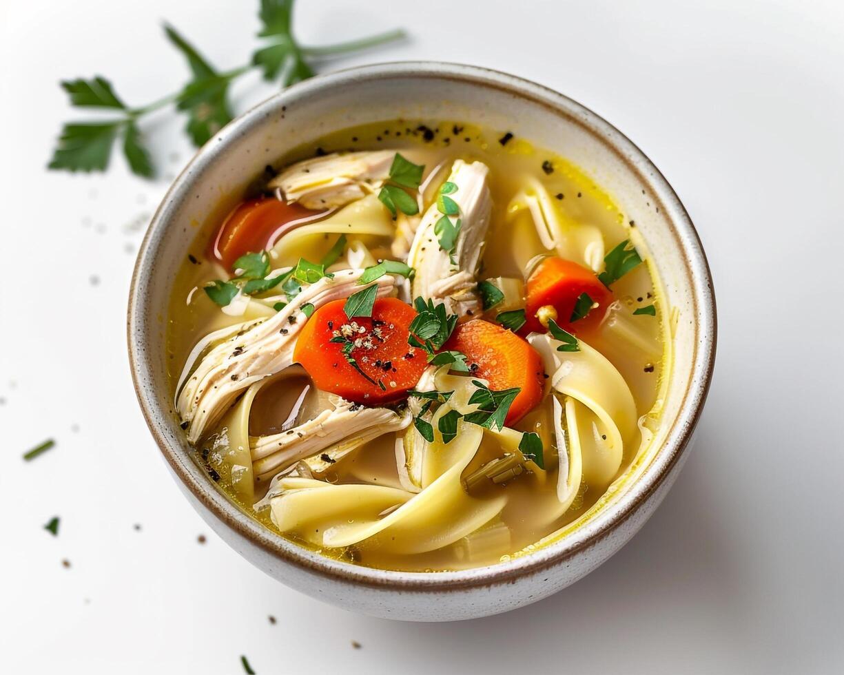 a bowl of chicken noodle soup with carrots and herbs background photo