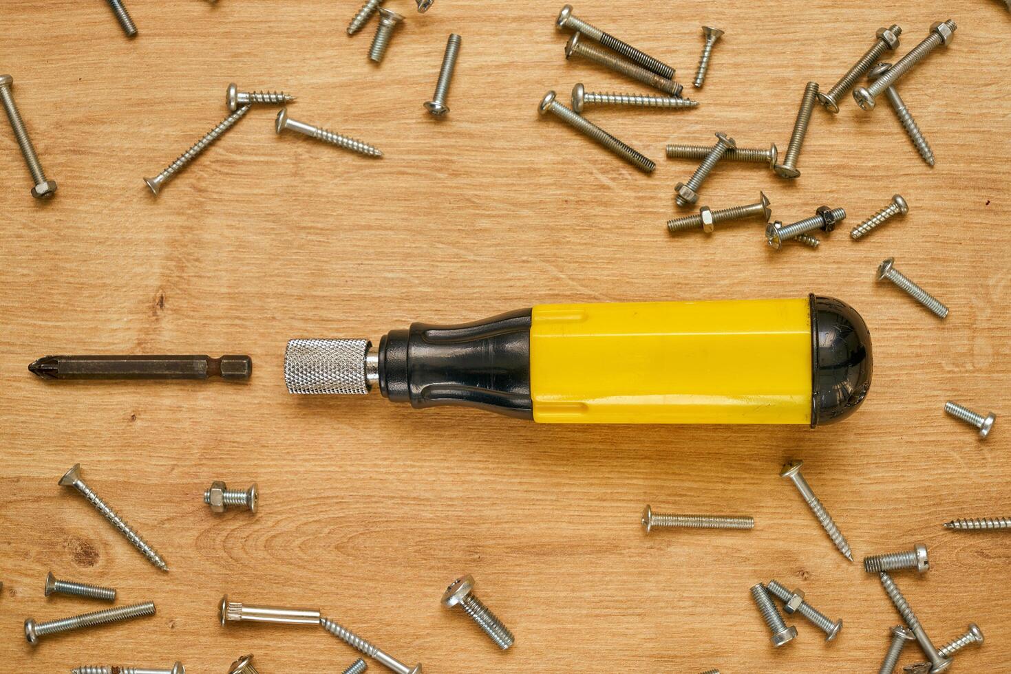 Screwdriver and screws on a table photo