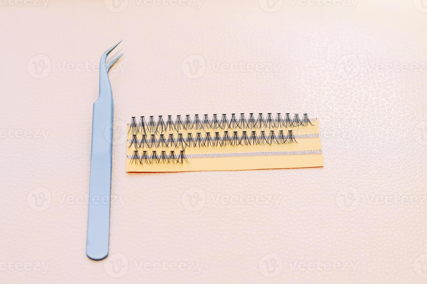 Artificial false fluffy eyelashes with tweezers. photo