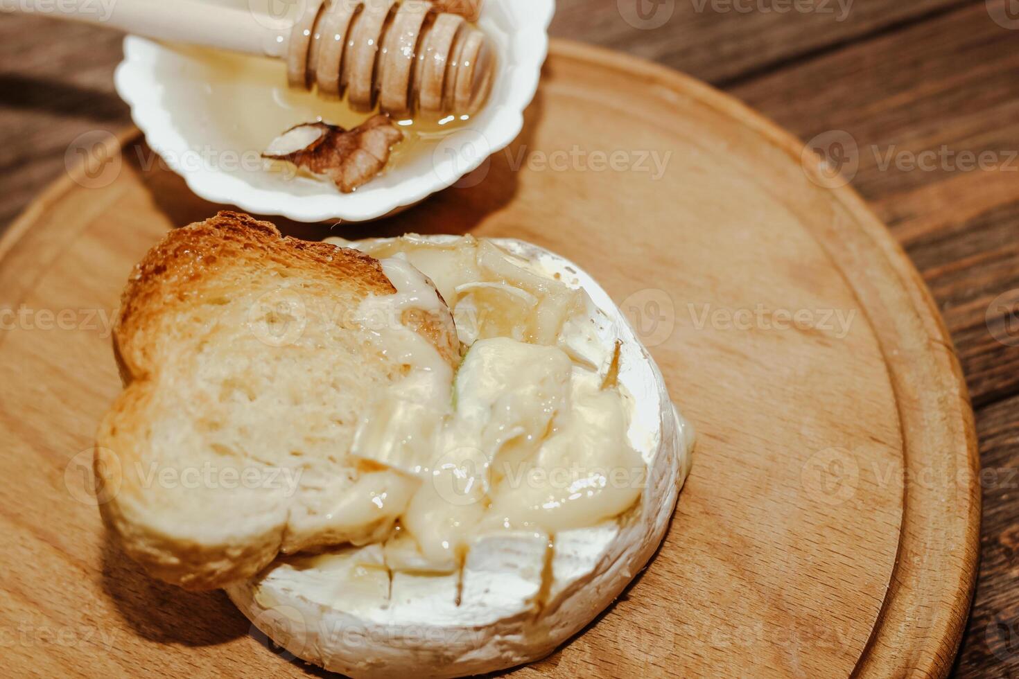 White baguette with olive oil and baked Camembert cheese on the table. photo