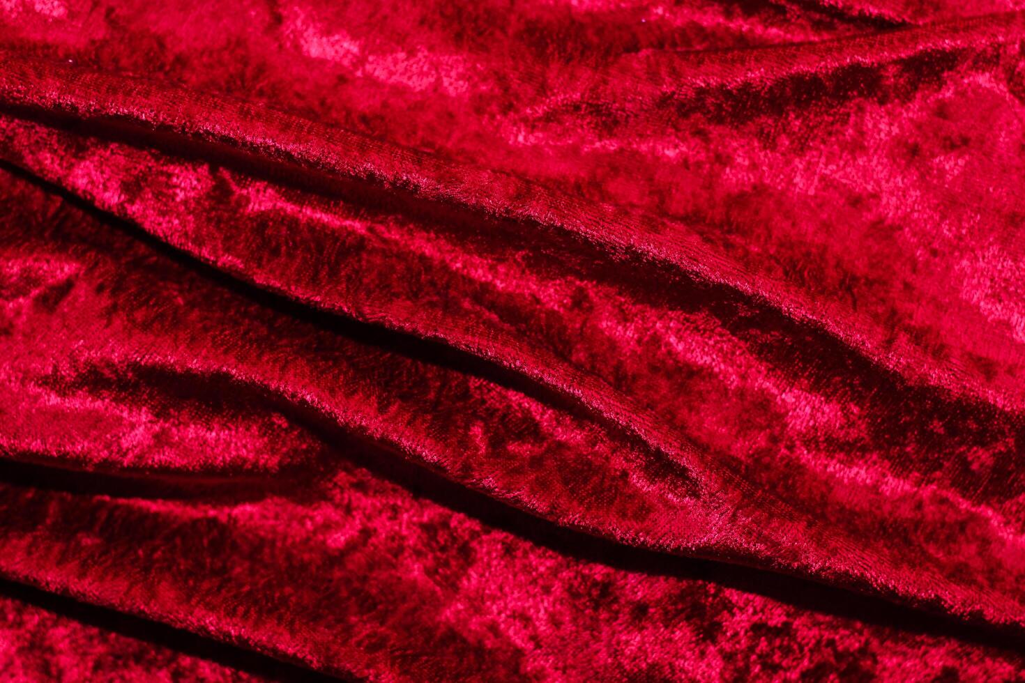Texture of red velor corduroy fabric with folds photo