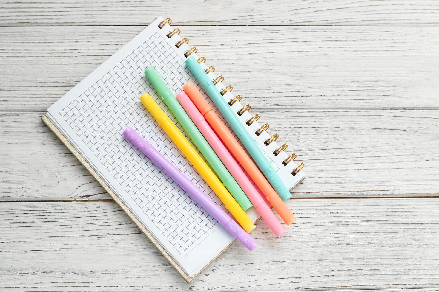 Notebook diary for planning and studying on the table with colored markers. photo