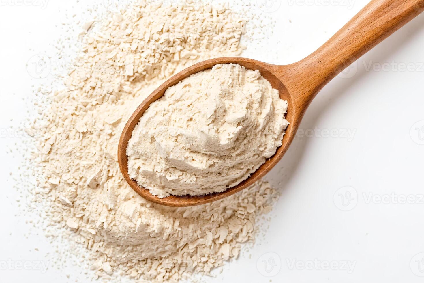 Close-up of a wooden spoon filled with white powder on a white background photo