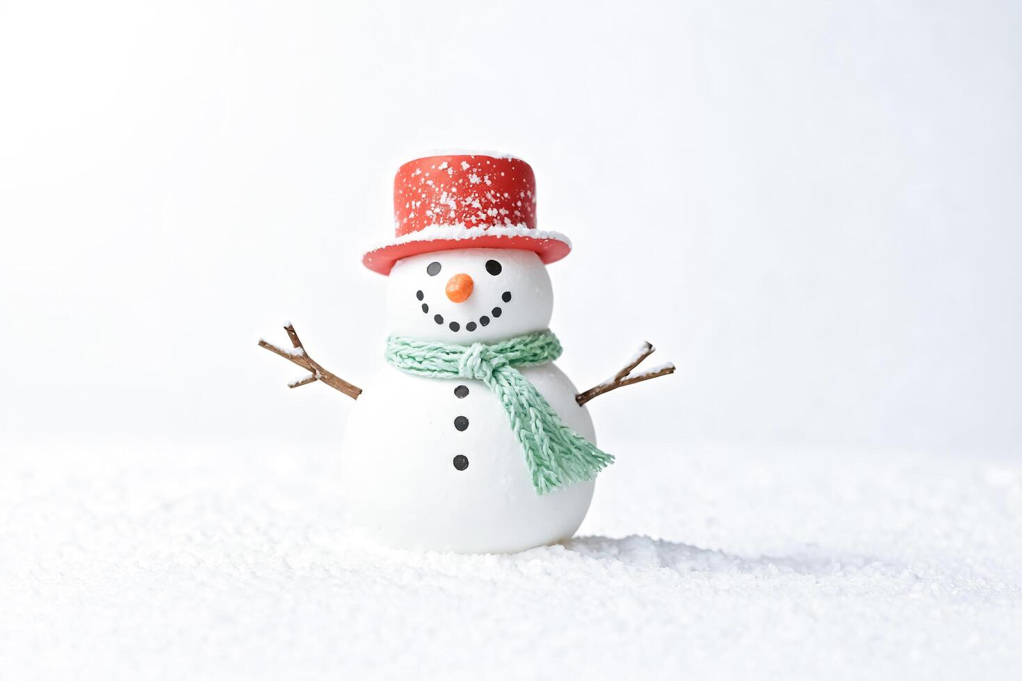 Snowman in a red hat and green scarf photo