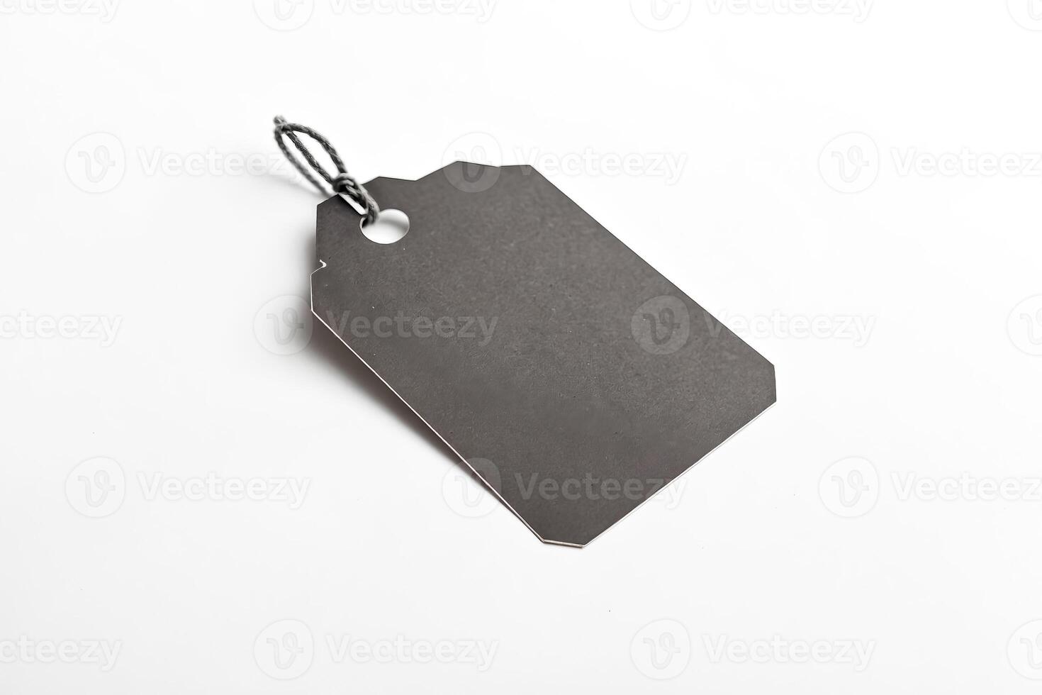 Blank black tag with string isolated on white background photo