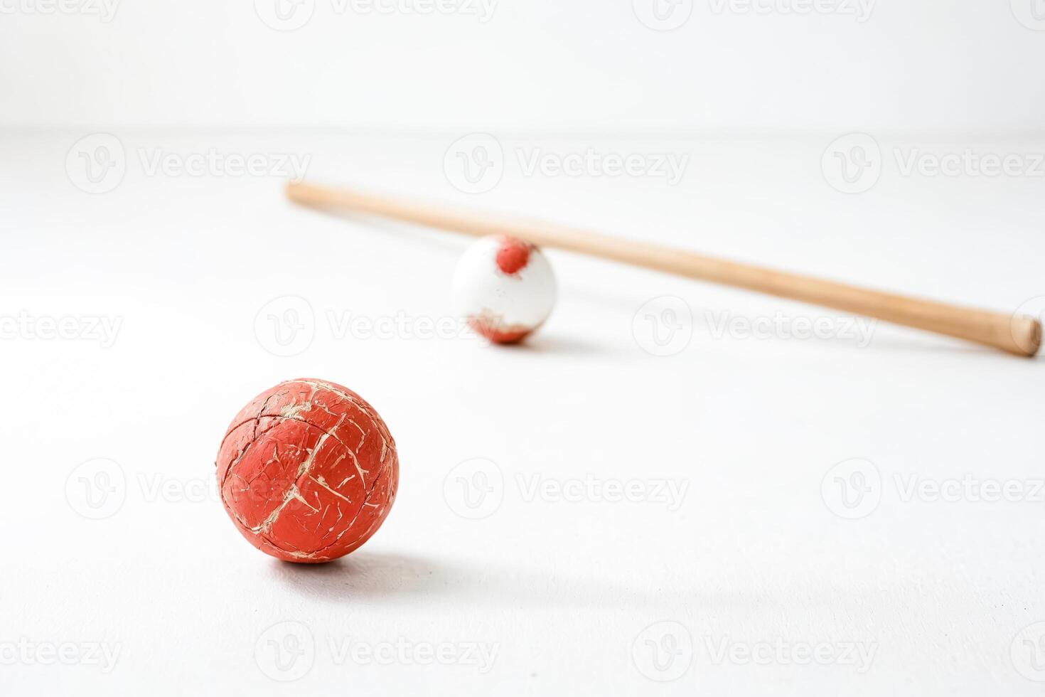 Close-up of red and white ball with wooden stick on white background photo