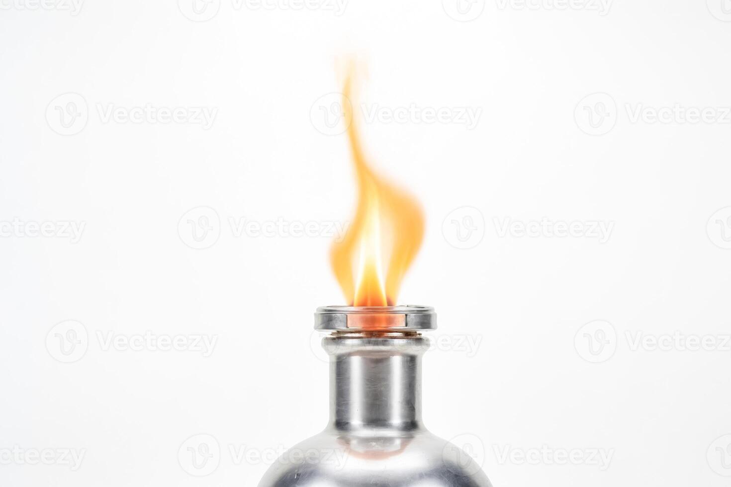 A silver flask with a flame burning from the top photo