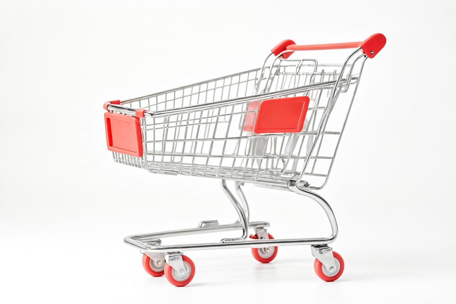 Empty shopping cart with red handles on a white background photo