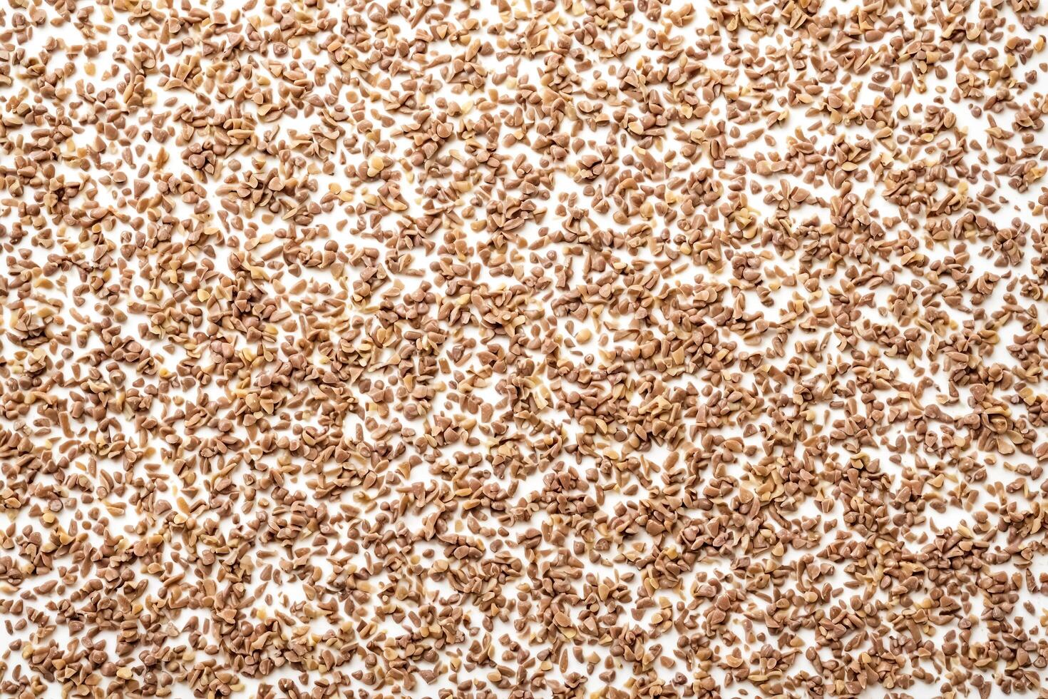 Close-up of Brown Granules Scattered on White Surface photo