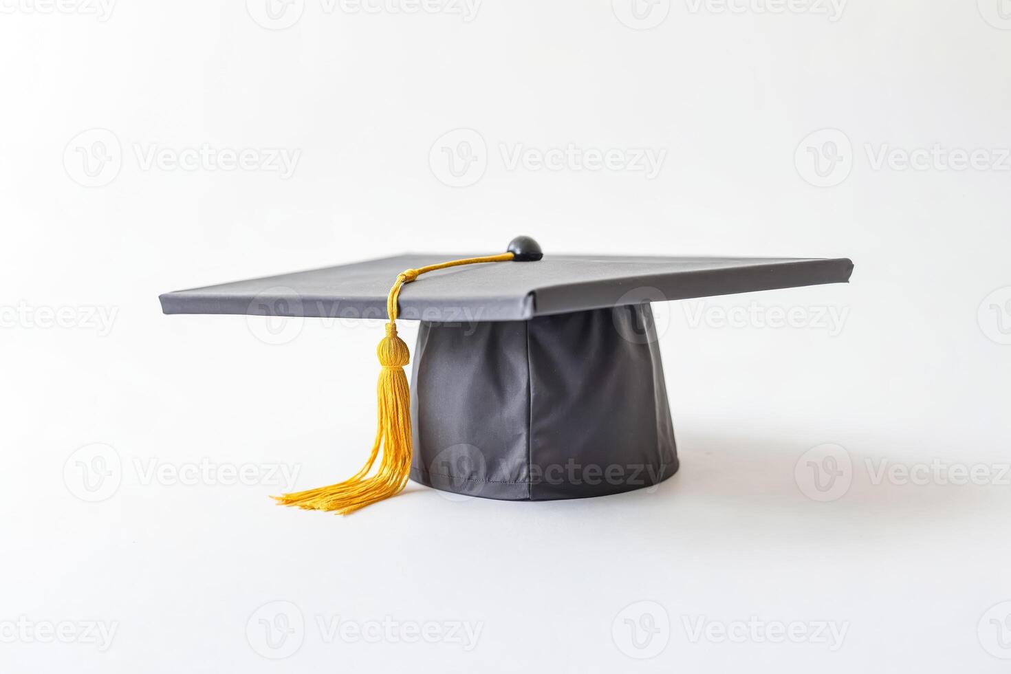 Black graduation cap with a yellow tassel on a white background photo