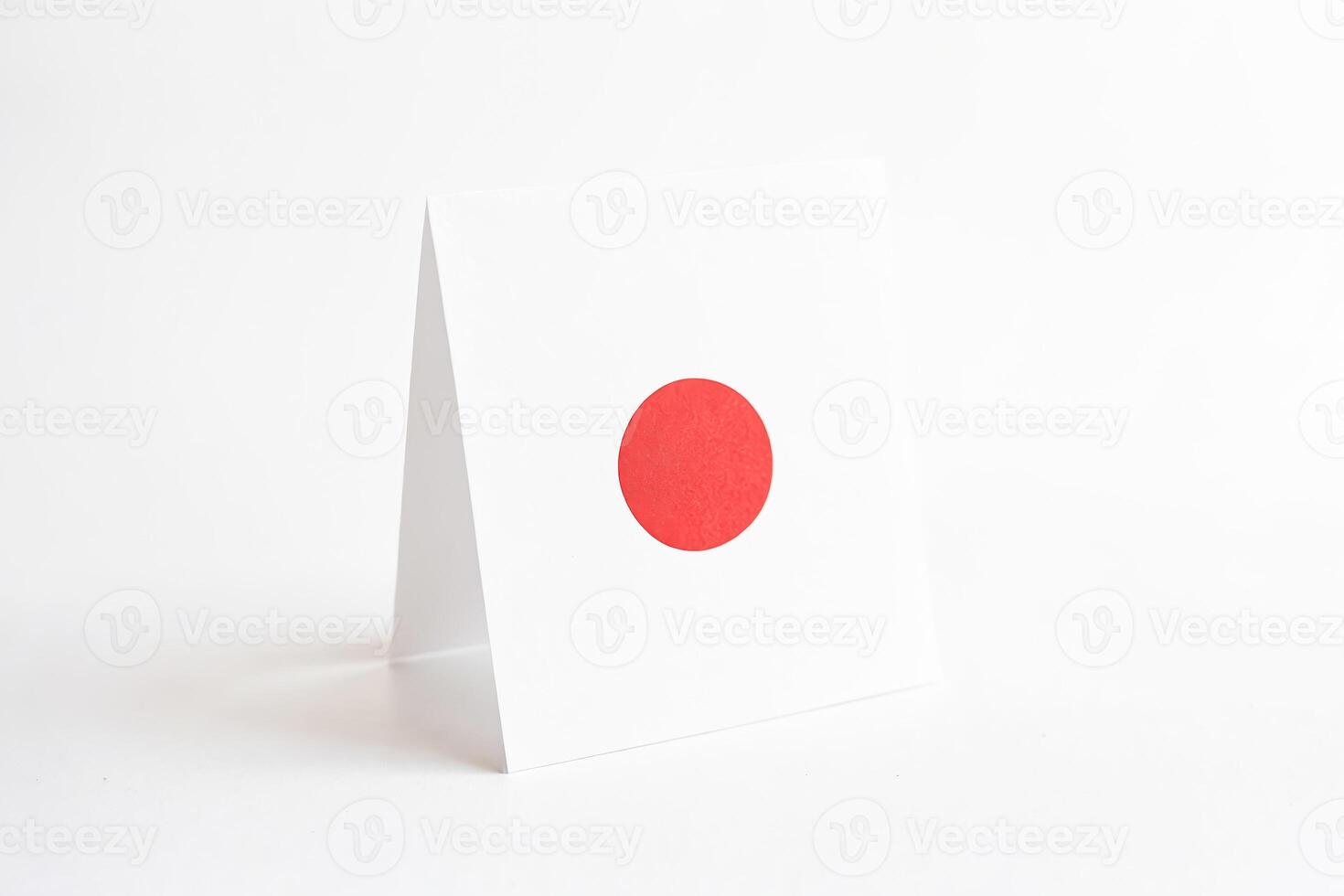 Folded Piece of Paper with a Red Circle on White Background photo