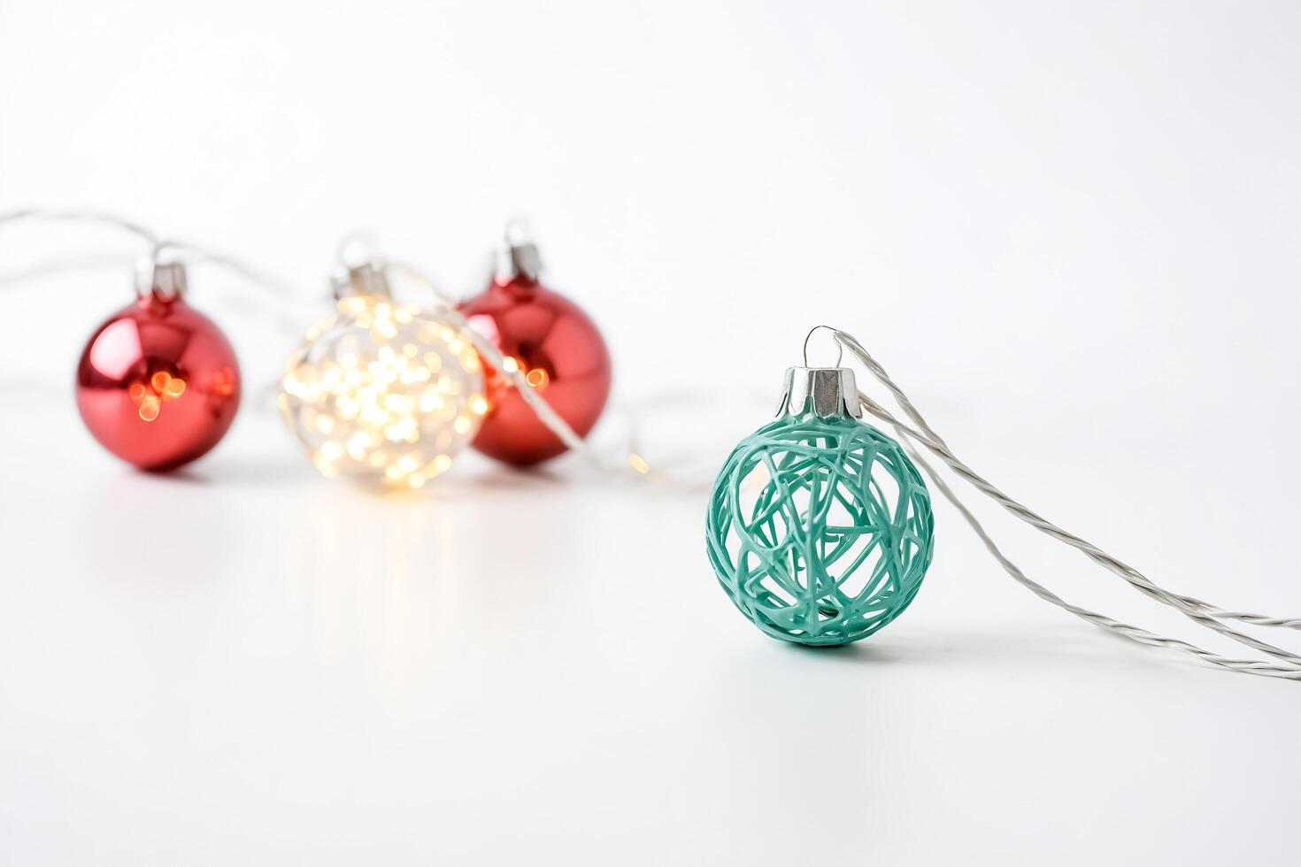 Teal Christmas Ornament with String Lights and Red Ornaments in the Background photo