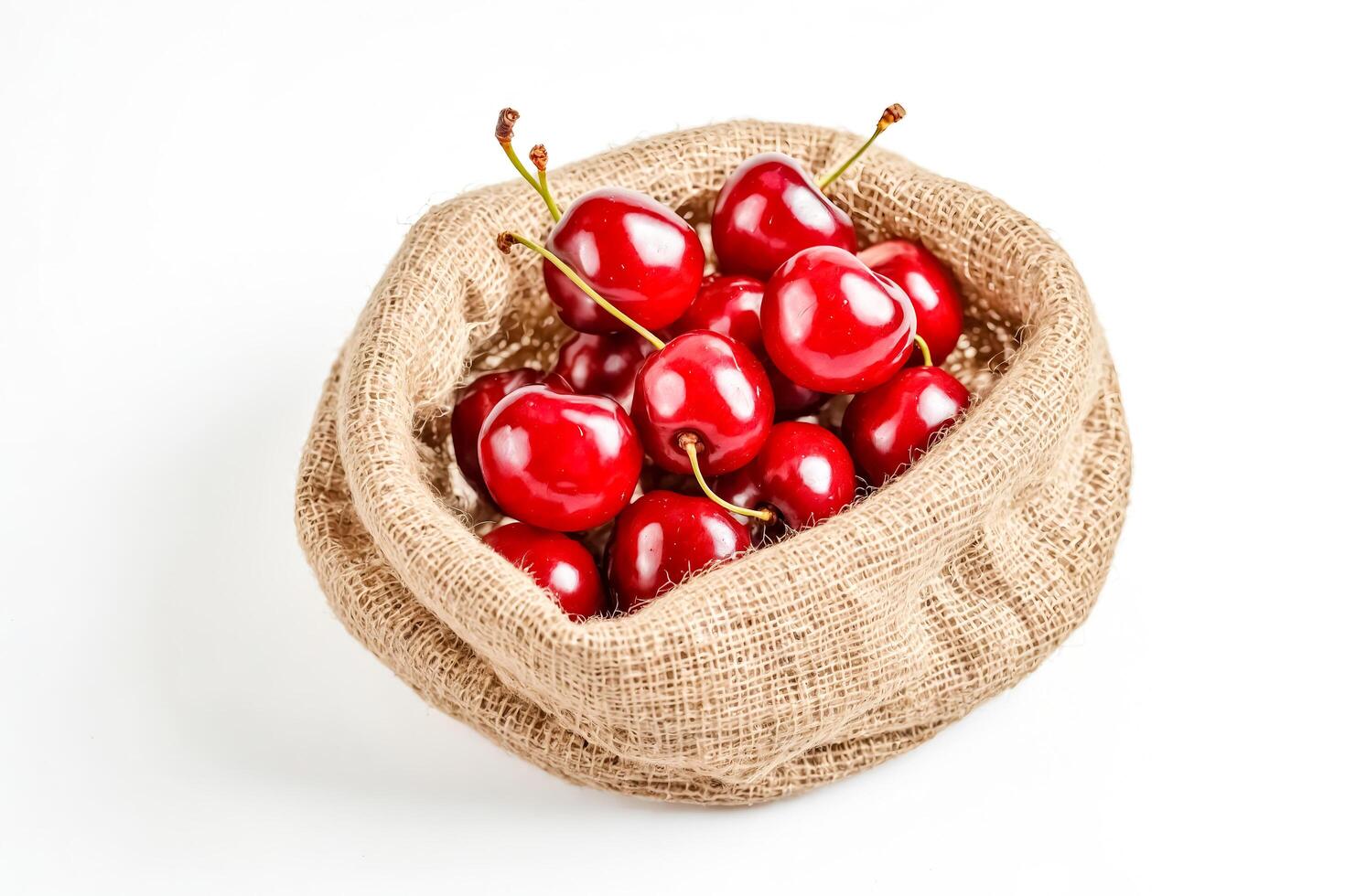 Close-up of Cherries in a Burlap Sack on a White Background photo