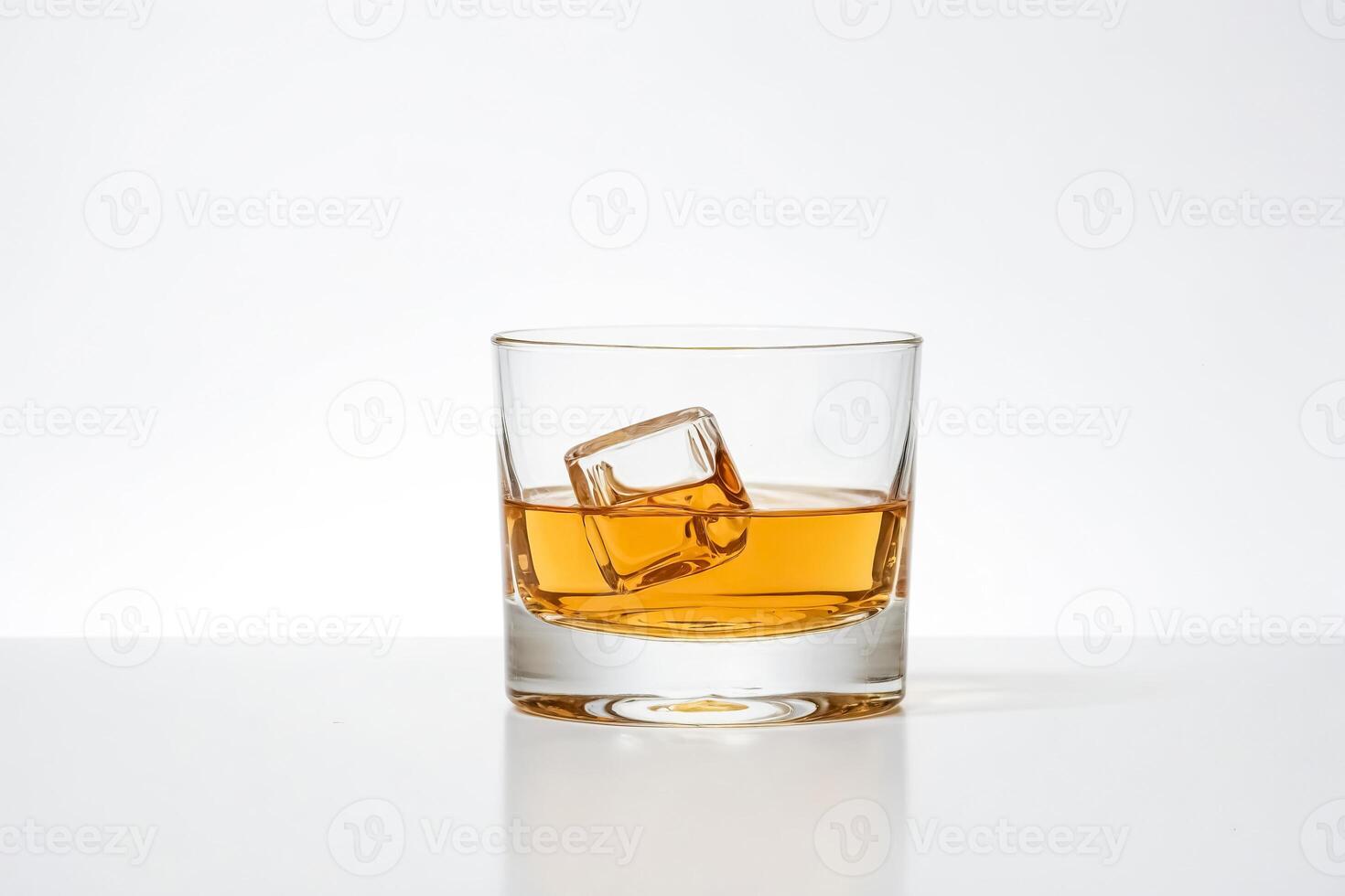 Glass of whiskey with ice cube photo