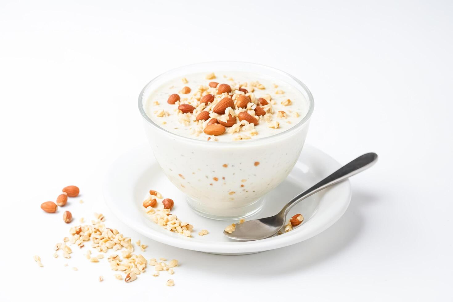 Bowl of yogurt with nuts and a spoon on a saucer photo