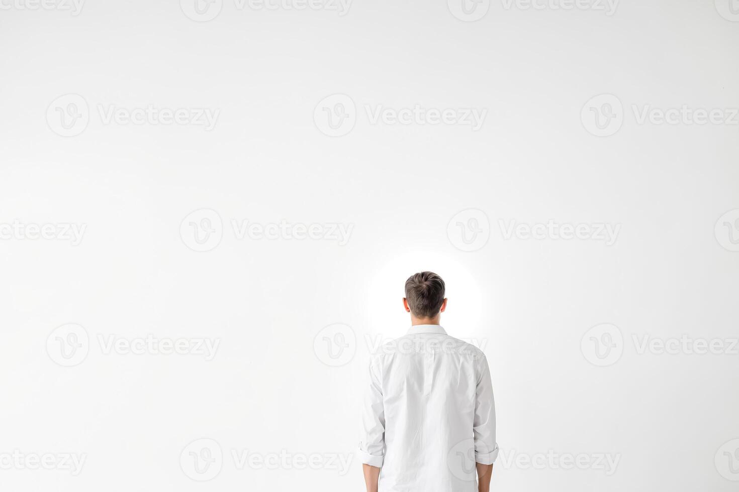 Man in White Shirt Standing in Front of a White Wall photo