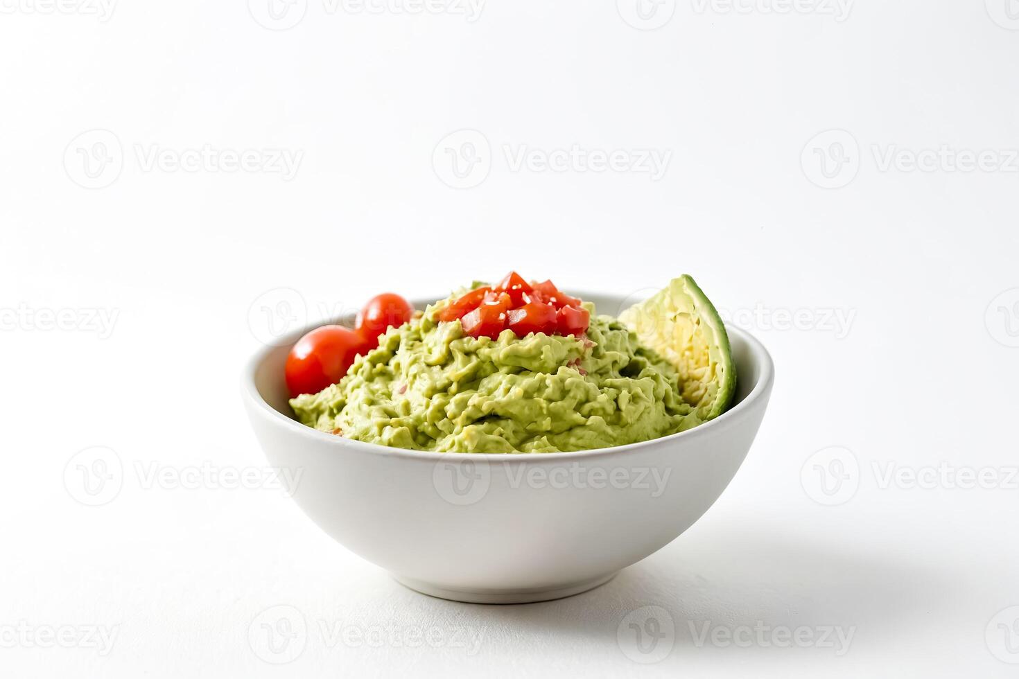 Guacamole in a bowl with cherry tomatoes and avocado skin photo