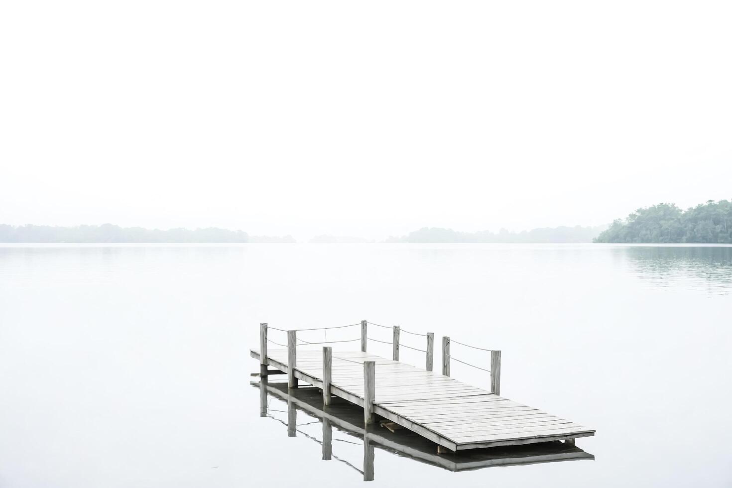 Wooden Dock Extends Into Misty Lake photo