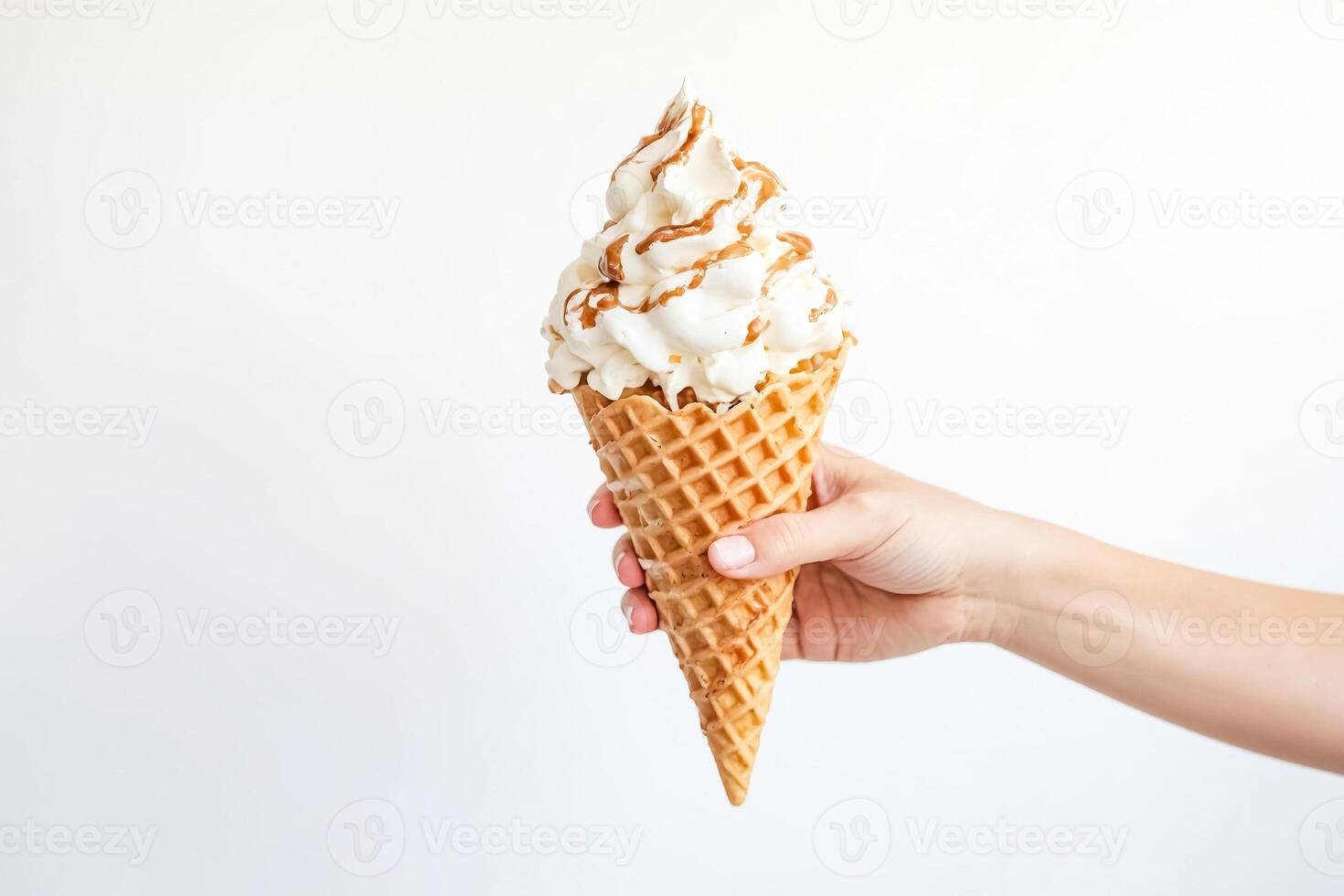 Hand Holding Ice Cream Cone with Caramel Drizzle photo