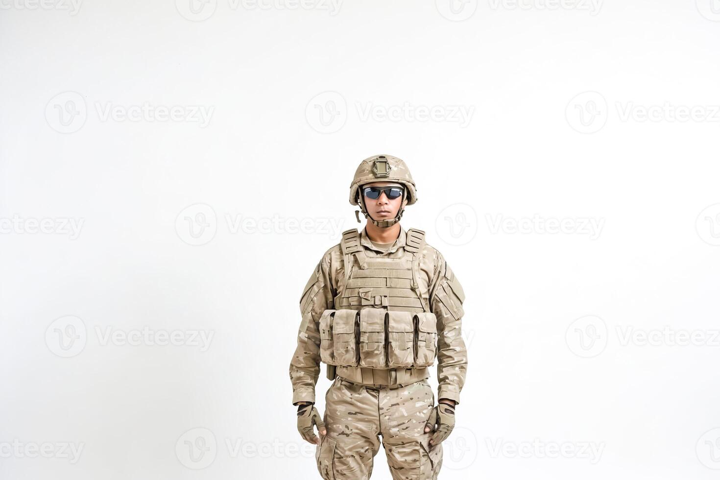 Portrait of a soldier in desert camouflage standing against a white background photo