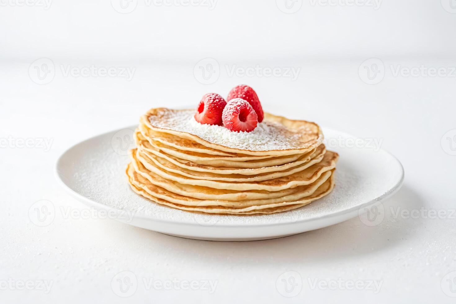 Stack of Pancakes with Powdered Sugar and Raspberries on a White Plate photo