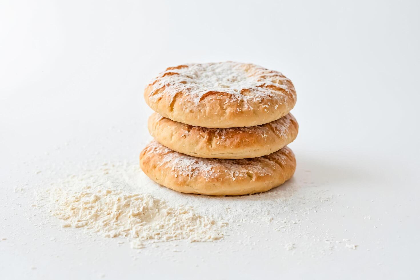 Three Homemade Doughnuts in Powdered Sugar on White Background photo