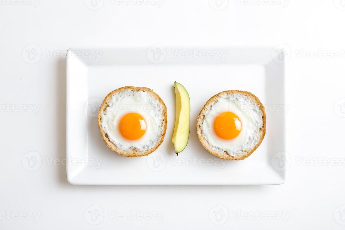 Fried Eggs in Bread Bowls with Avocado Slice photo