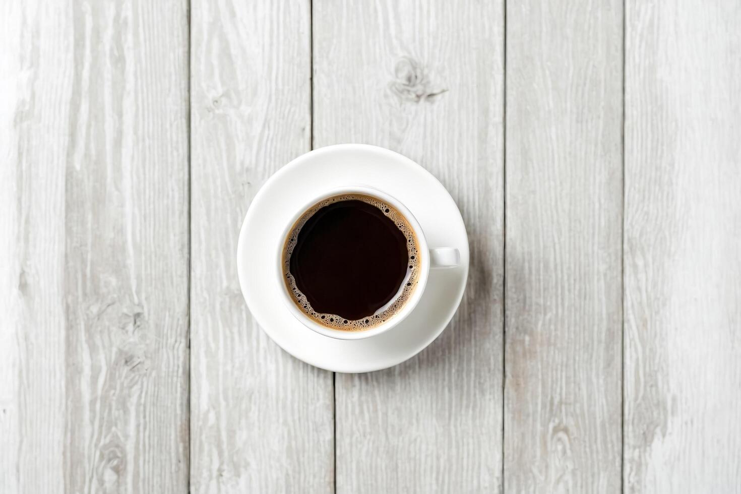 Top View of a Cup of Coffee on a White Wooden Table photo