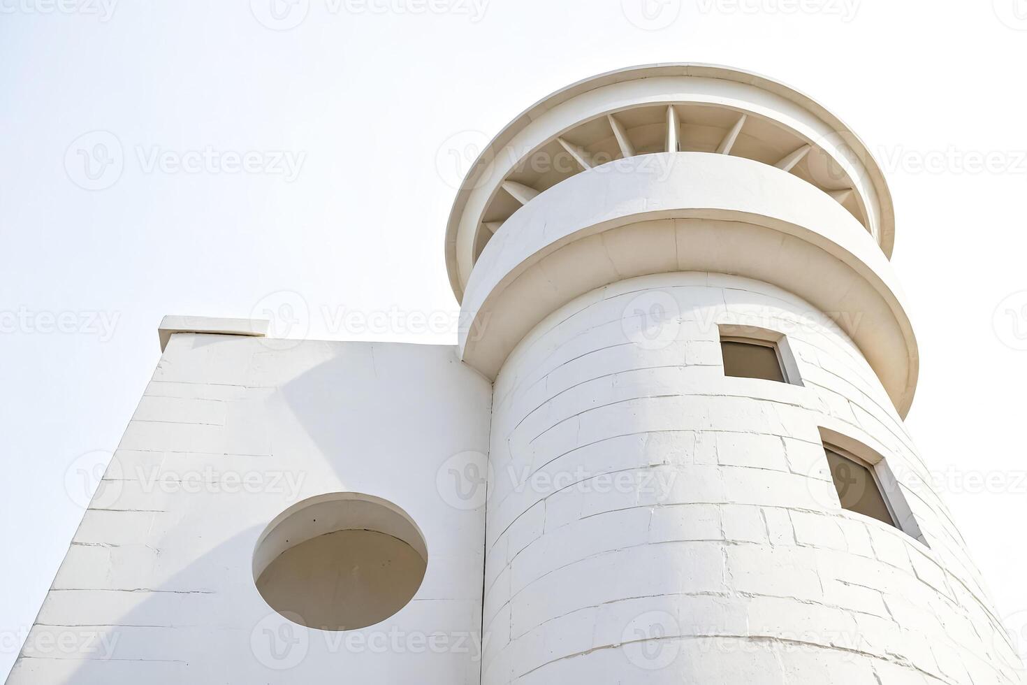 White lighthouse tower with round window photo