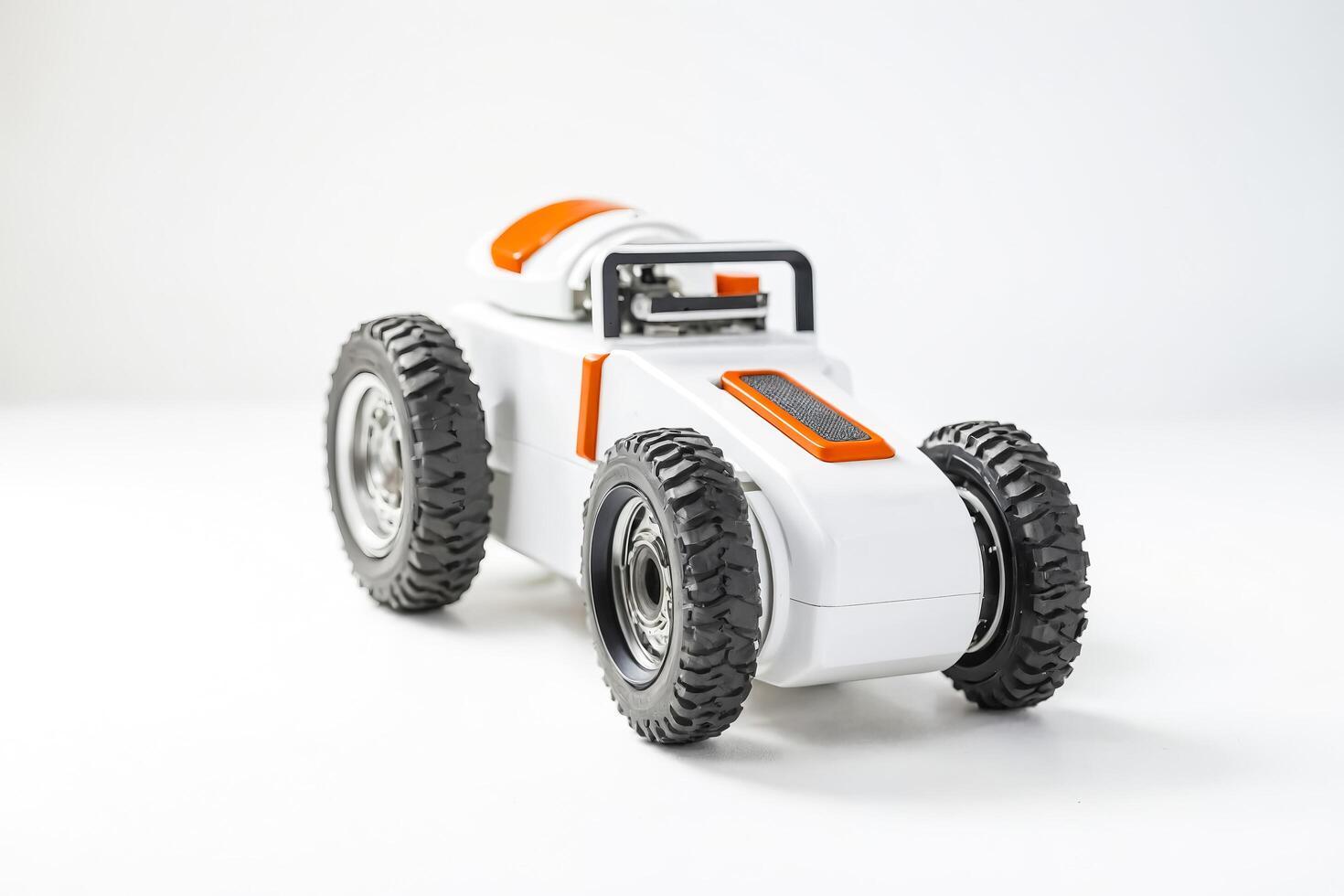 White toy car with orange accents and black tires on white background photo