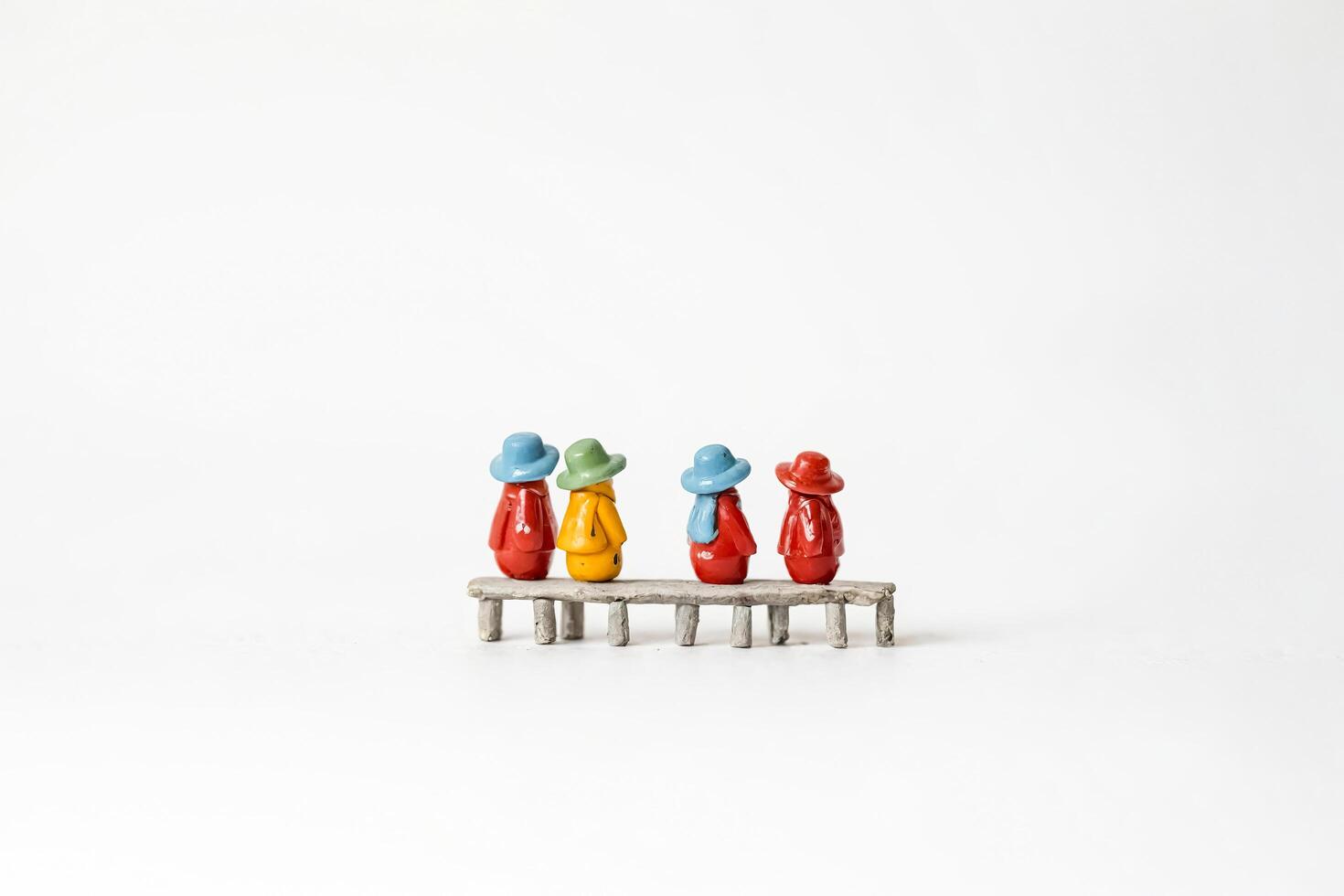 Four miniature figures sitting on a bench photo