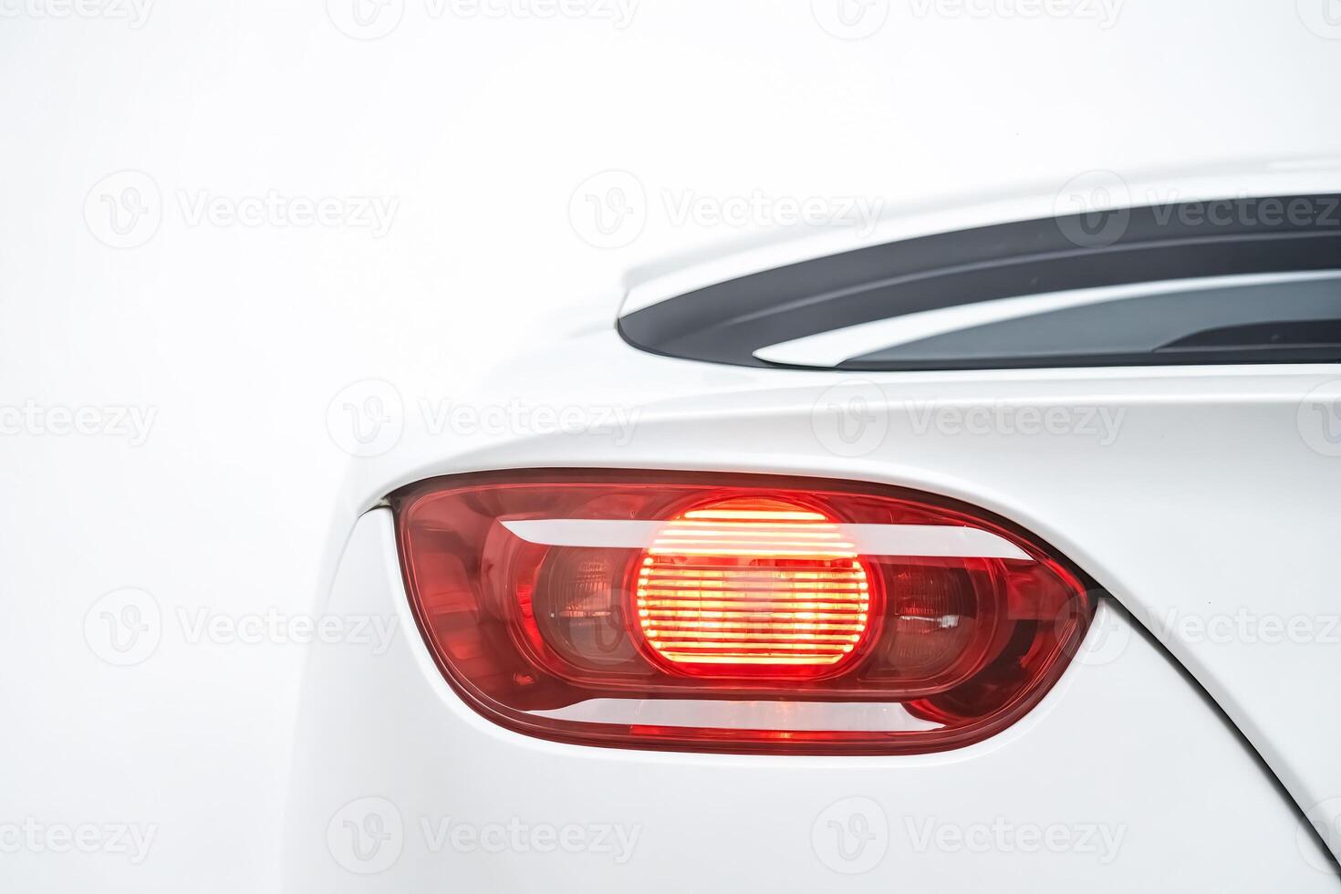 Closeup of a Red Taillight on a White Car photo