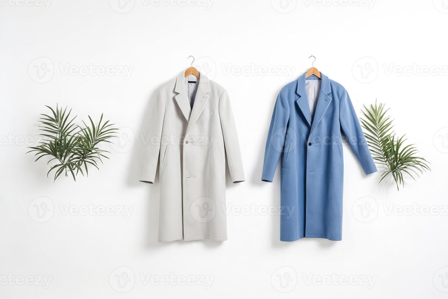 Two coats hanging on wooden hangers against a white background photo