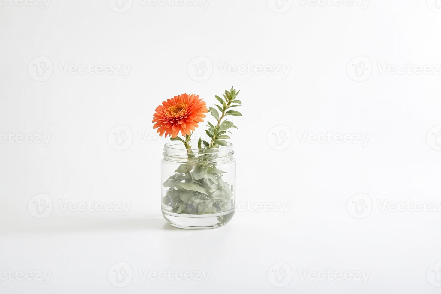 Single orange gerbera daisy in a glass jar photo