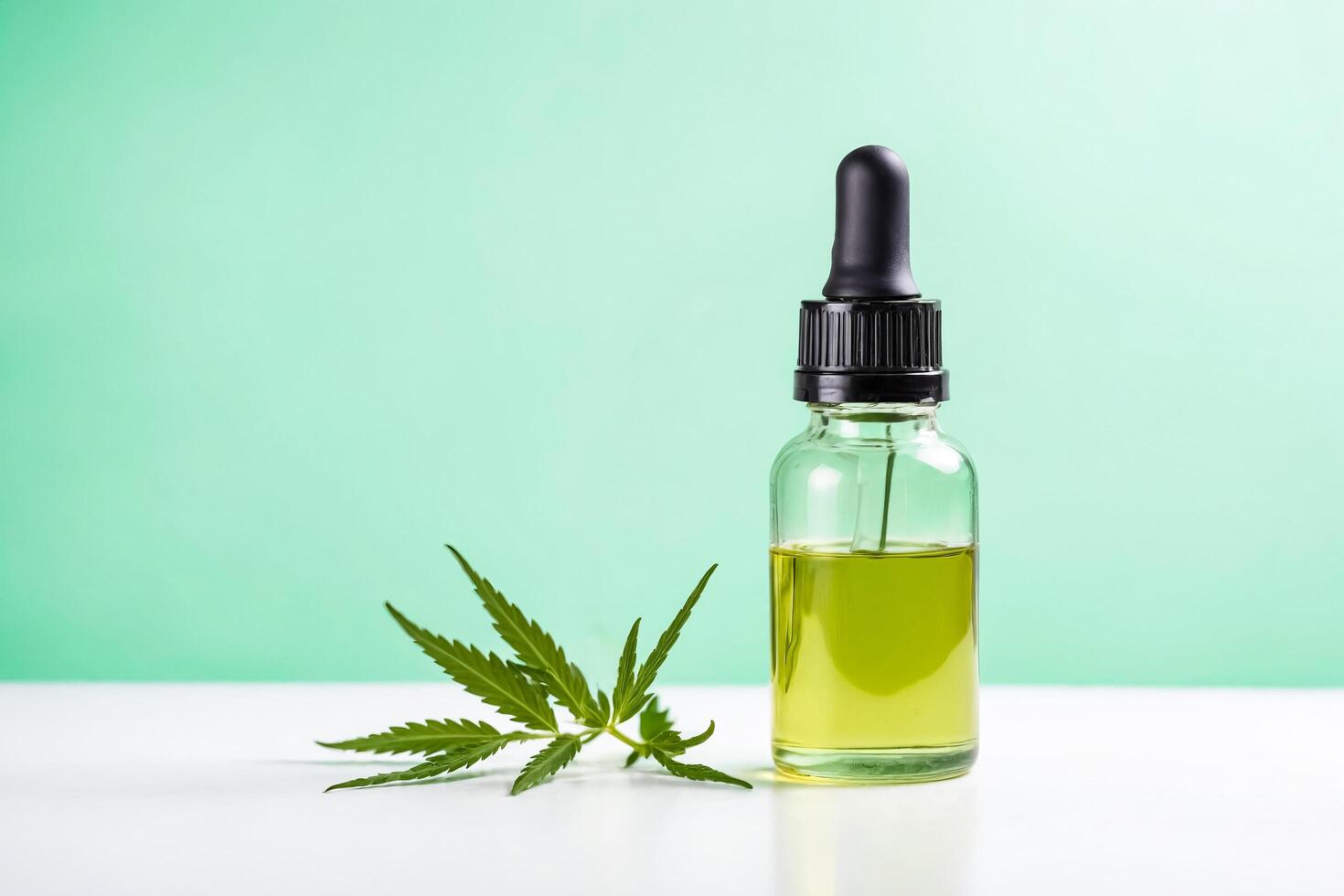 CBD Oil Dropper Bottle with Hemp Leaf on White Surface photo