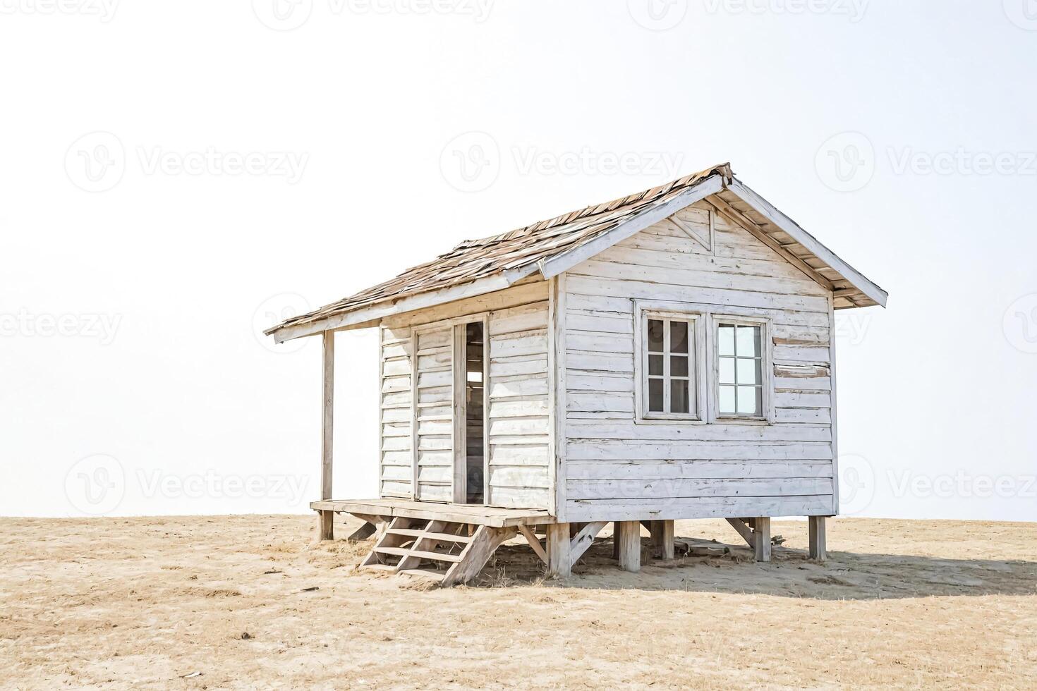 White Wooden Cabin on Sand with Blue Sky photo