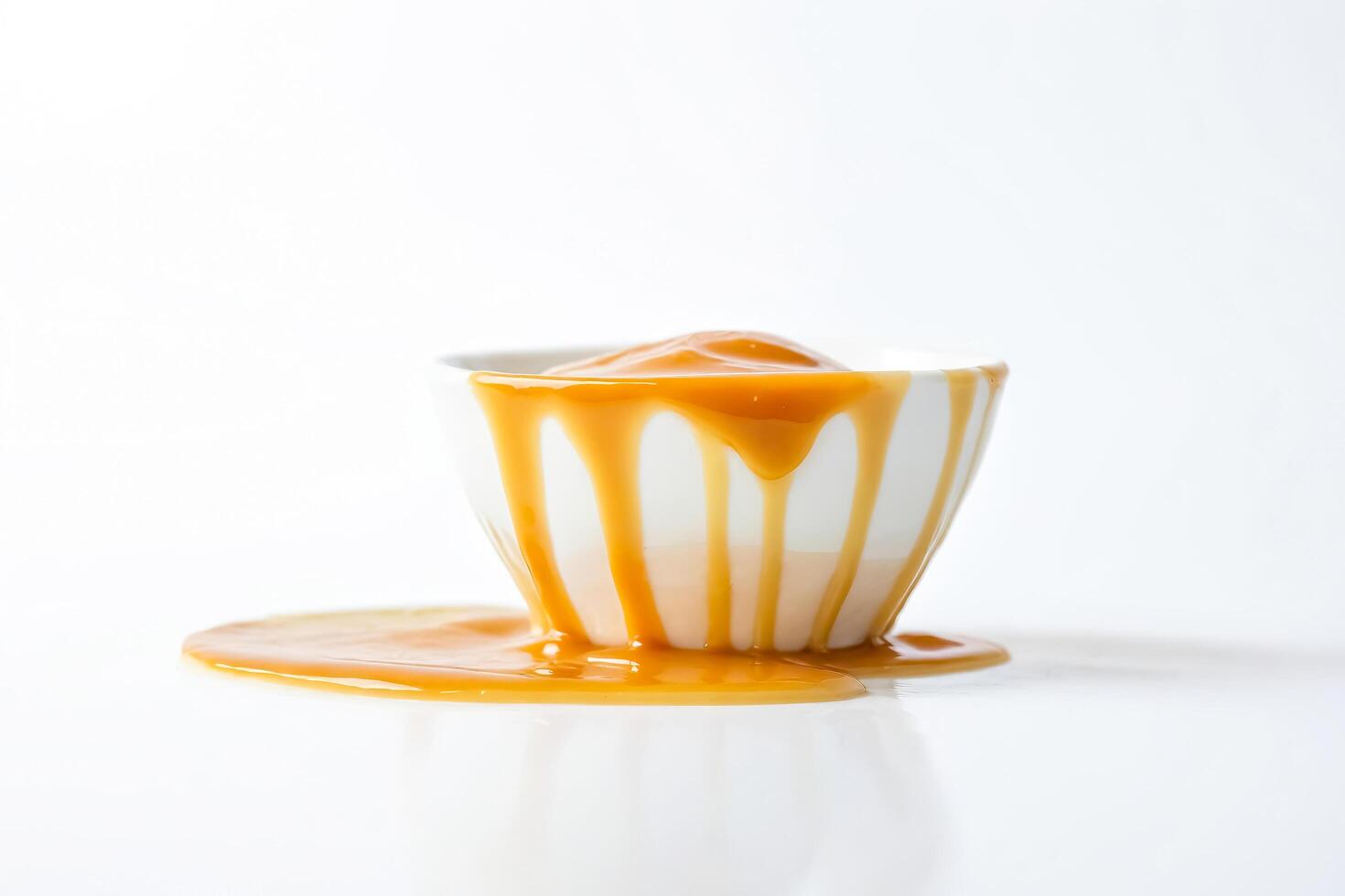 Dripping caramel sauce in a white bowl photo