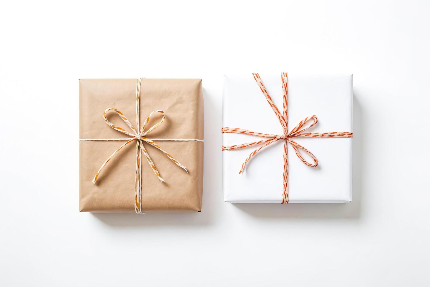 Two Presents Wrapped in Kraft Paper and White Paper with Orange and White Ribbon on White Background photo