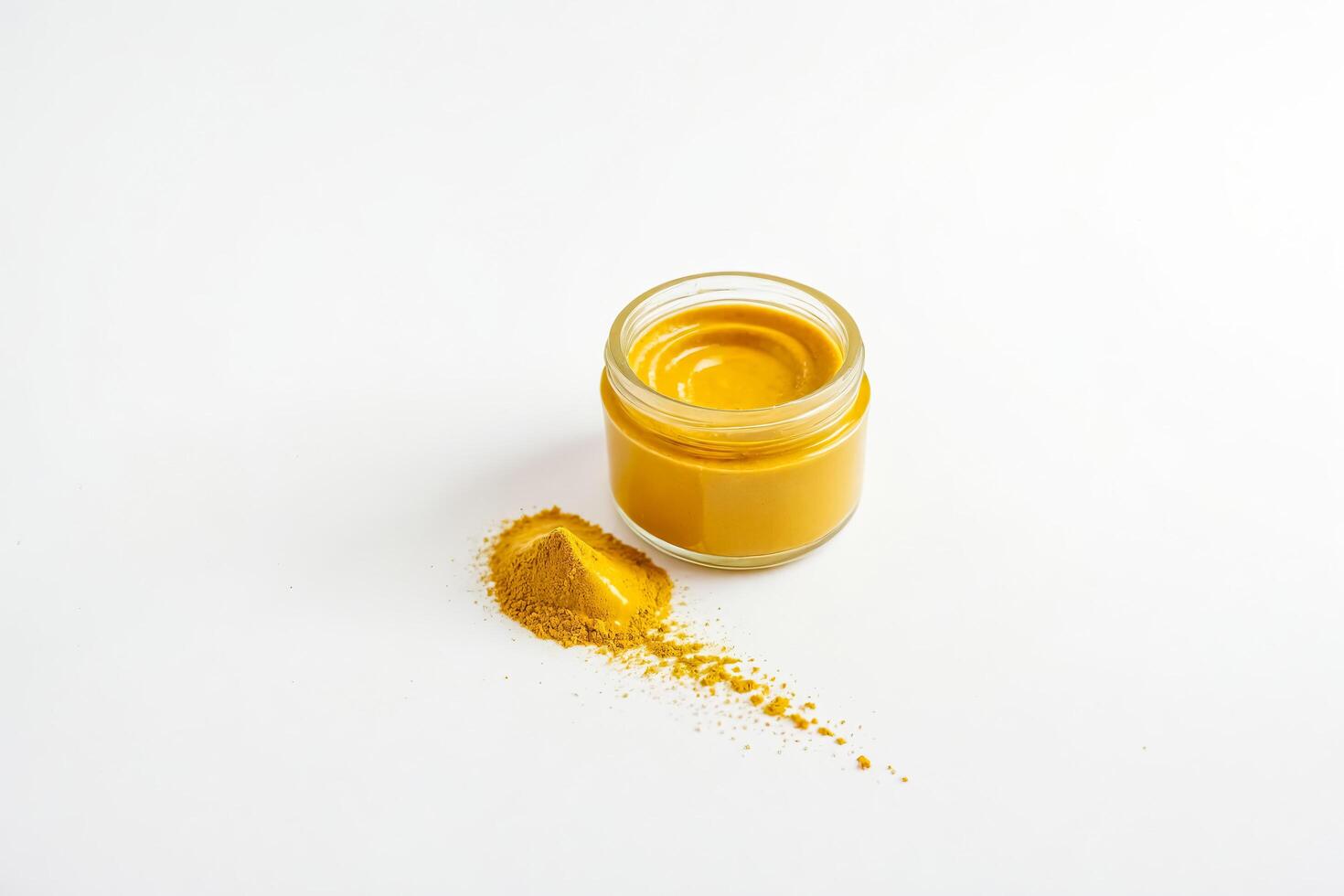 Turmeric powder and paste in glass jar on white background photo