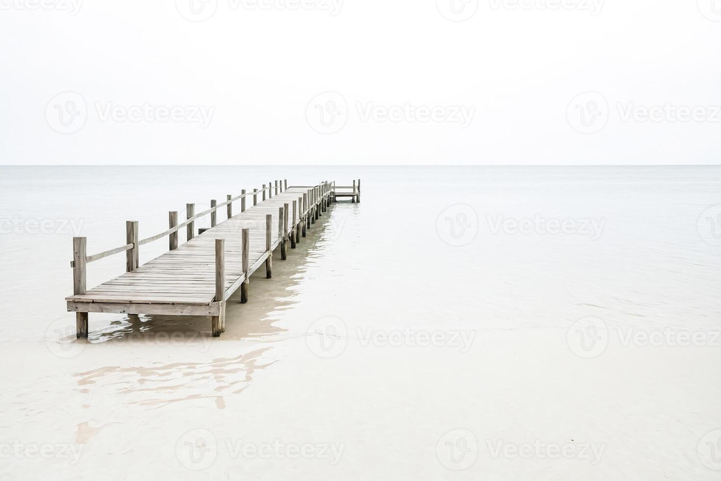 Wooden pier extending into a calm sea photo