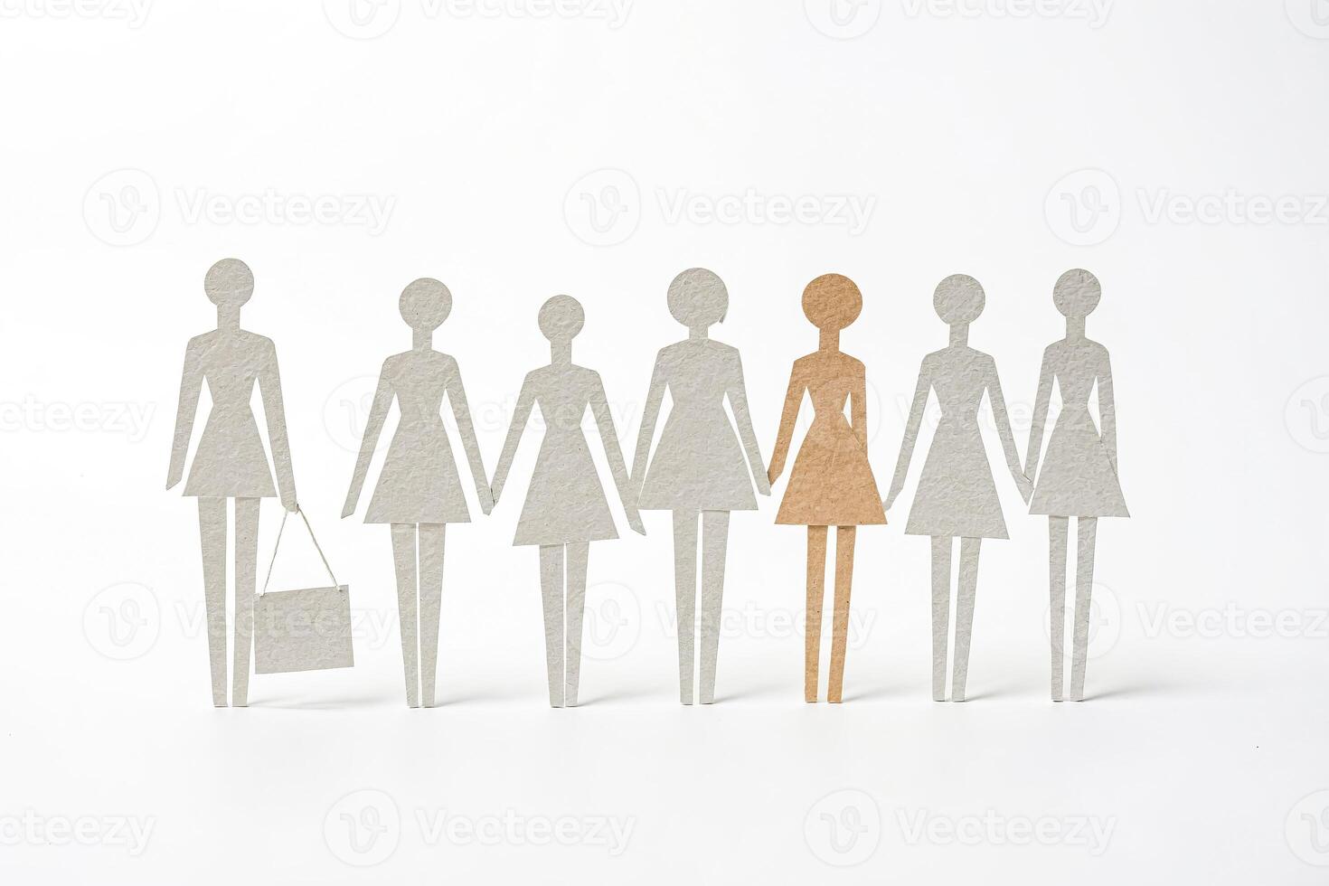 Paper cut-out people stand in a line, one different color photo