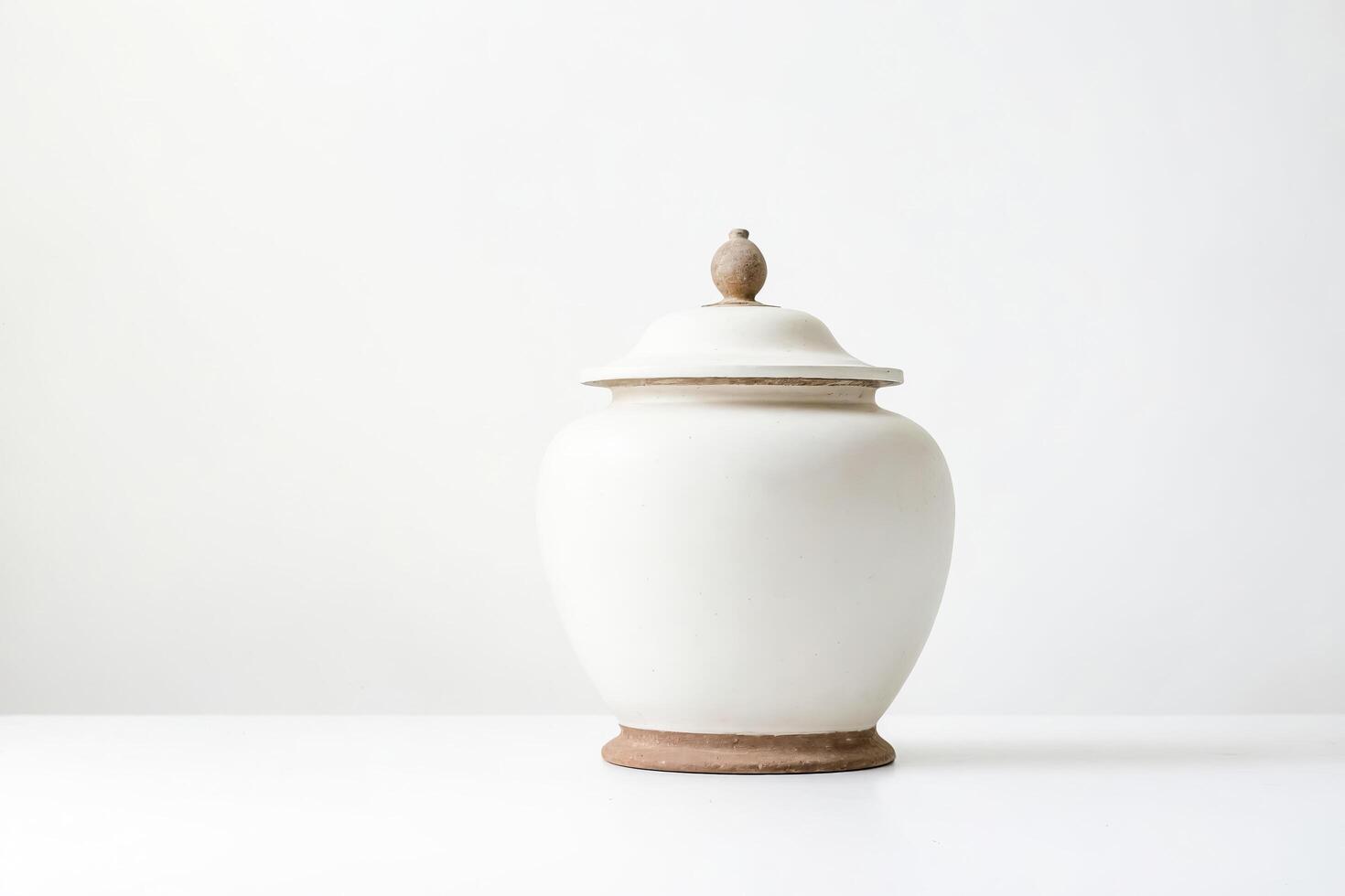 White ceramic vase with wooden lid on white background photo