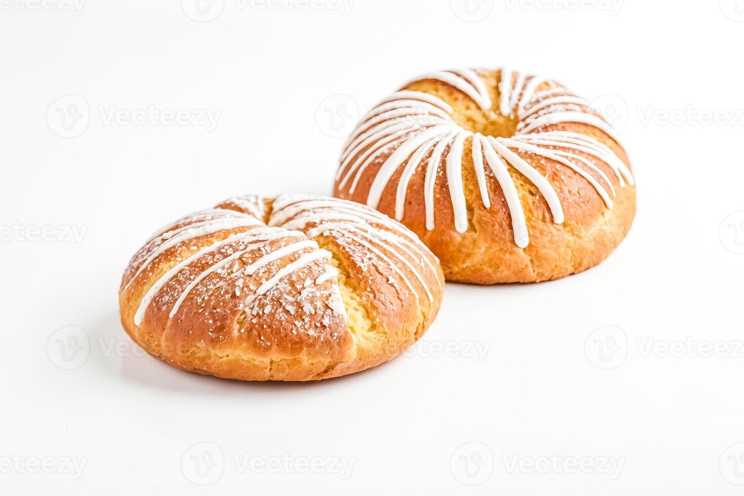 Two sweet brioche rolls with white icing and sugar sprinkles isolated on white background photo